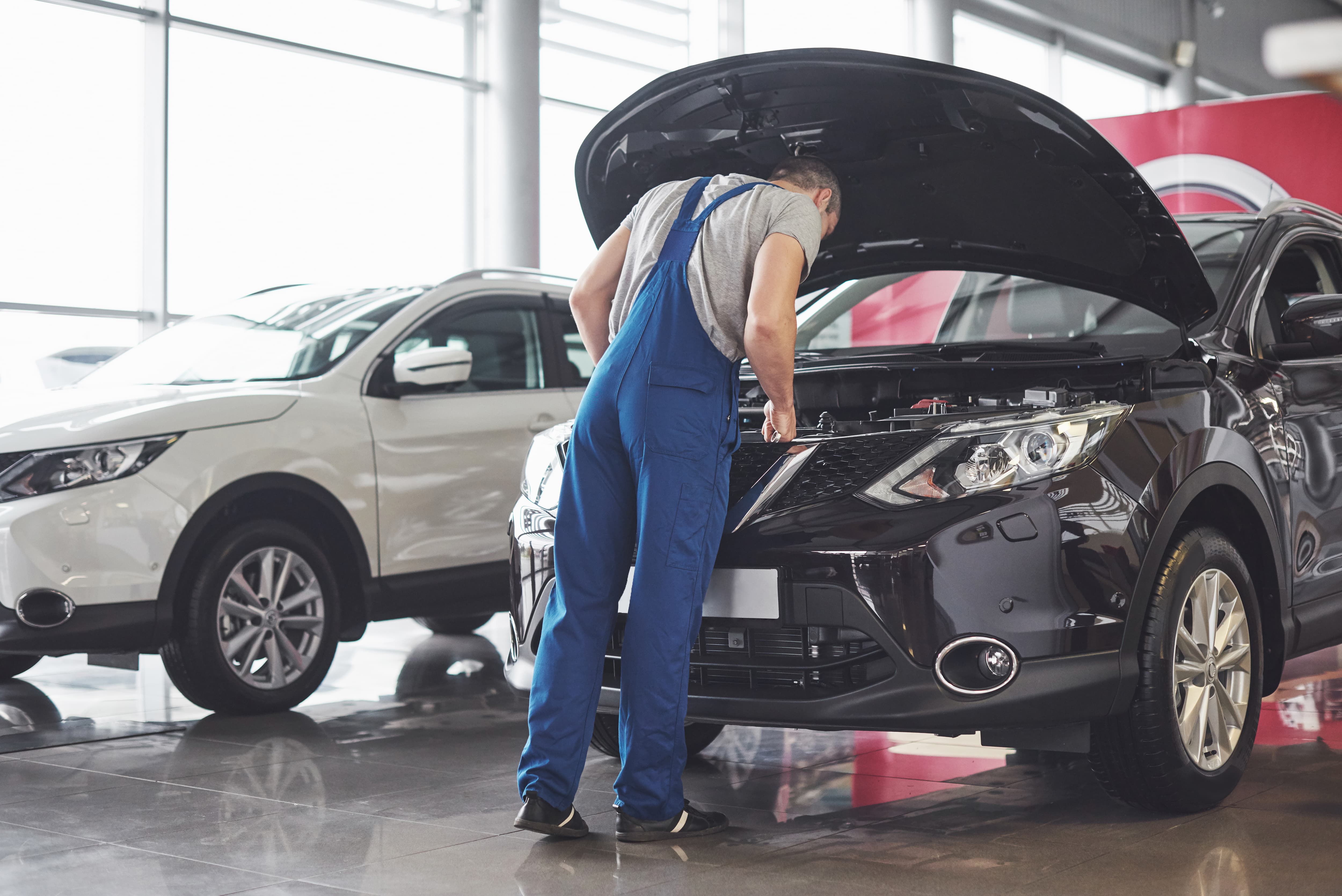 muscular-car-service-worker-repairing-vehicle.jpeg